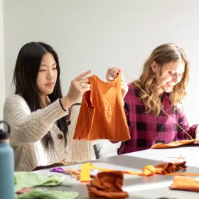 A student upcycles a t-shirt into a tote bag.